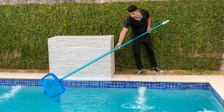 Person cleaning out a swimming pool